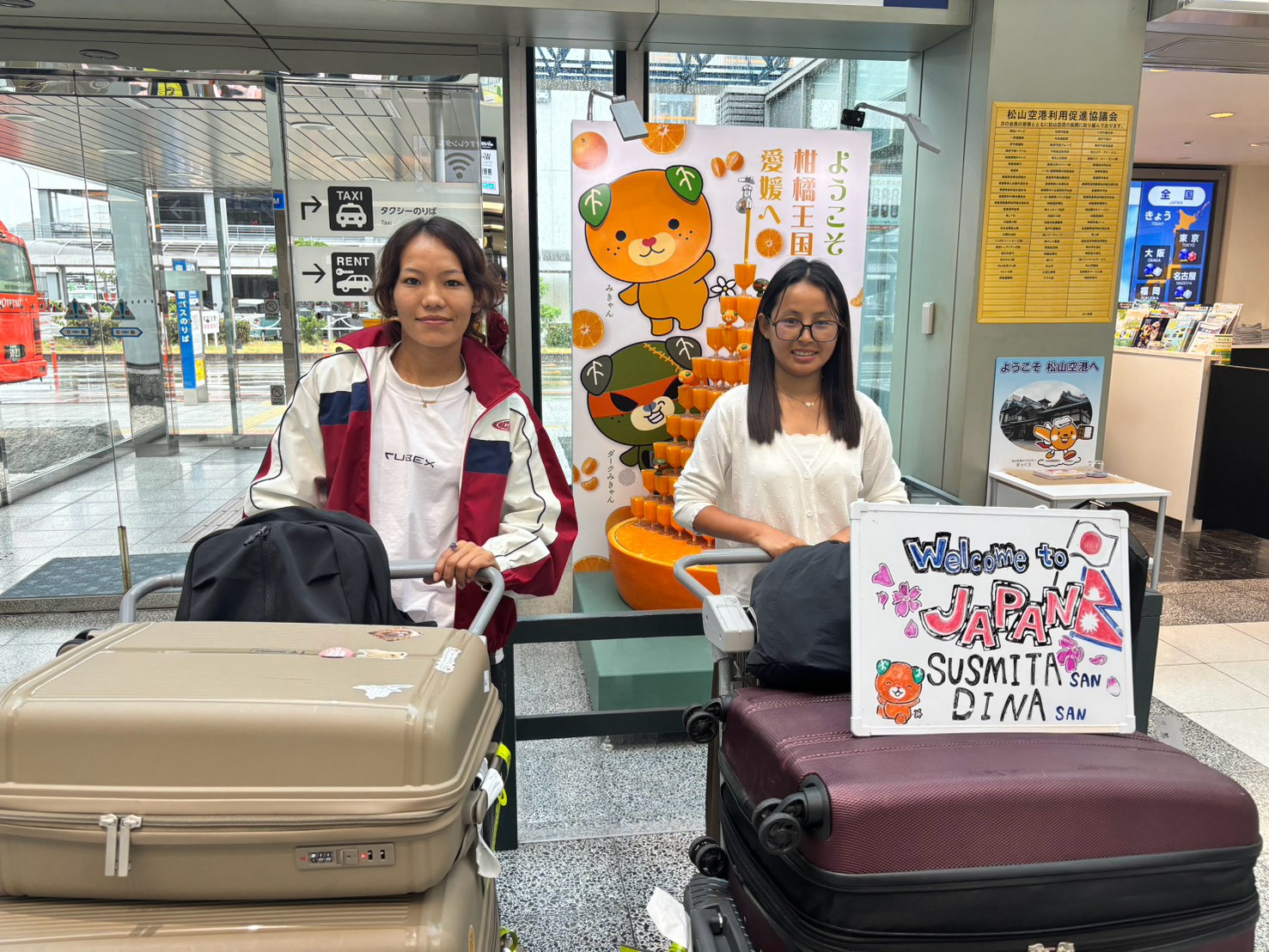愛媛・松山空港で特定技能のネパール人介護スタッフ2名をWelcome看板とともに出迎える受け入れ支援｜ワオライフ国際人材